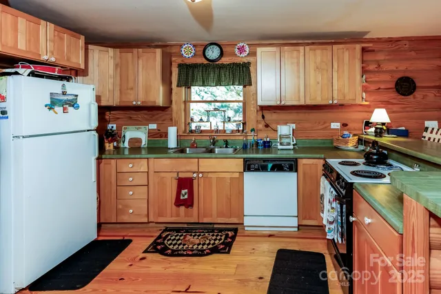 a kitchen with stainless steel appliances granite countertop a refrigerator a sink and a stove