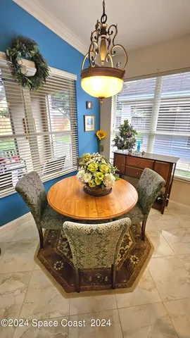 a dining room with furniture a floor to ceiling window and potted plants