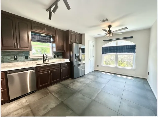 an empty room with windows and fan