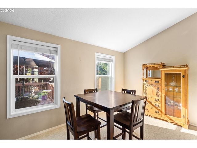 a kitchen with stainless steel appliances granite countertop a dining table chairs and a refrigerator