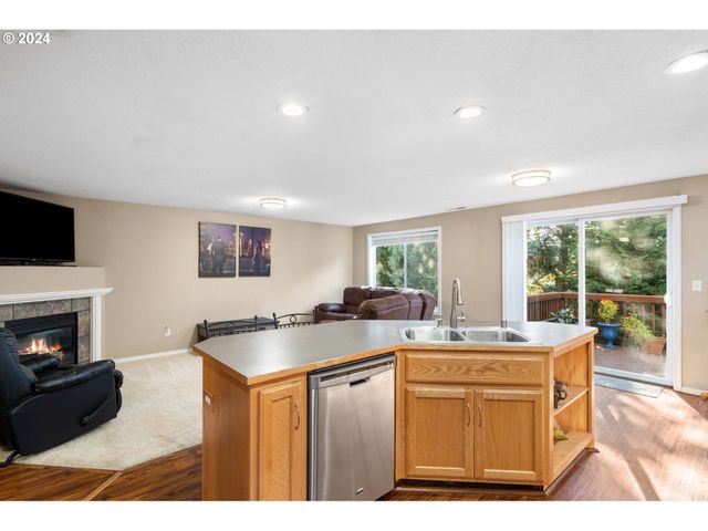 a kitchen with stainless steel appliances kitchen island granite countertop a stove top oven a sink a counter top space and living room view