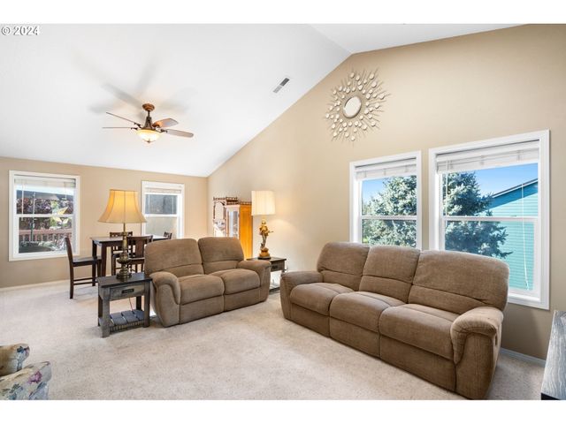 a living room with furniture kitchen view and a window