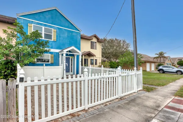 a front view of a house with white fence