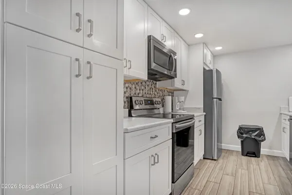 a kitchen with stainless steel appliances a refrigerator sink and microwave