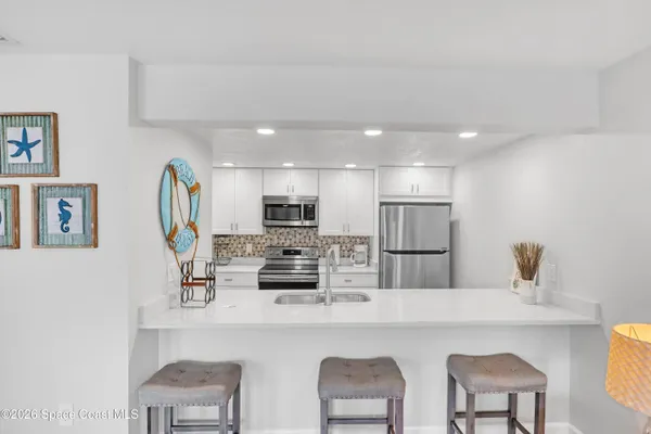 a kitchen with stainless steel appliances a refrigerator and a stove top oven