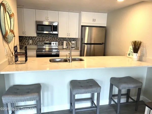 a kitchen with stainless steel appliances a refrigerator and microwave