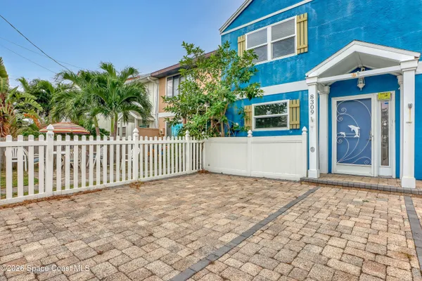a view of a house with a small yard and wooden floor and fence