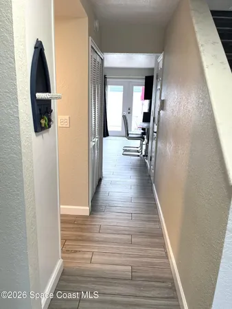 a view of a hallway with wooden floor and staircase