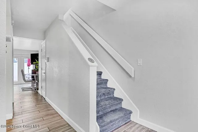 a view of a hallway with wooden floor and stairs