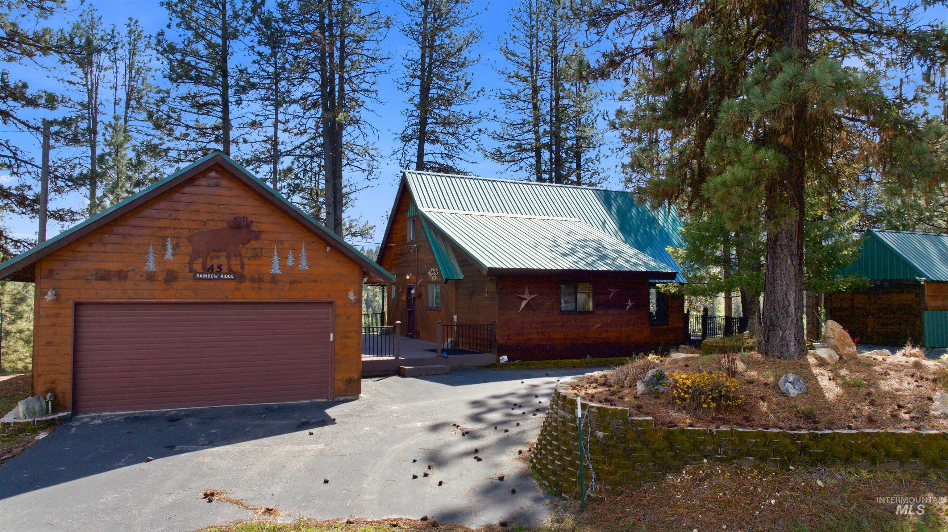 View of front of house with a deck, an outbuilding, and a metal roof