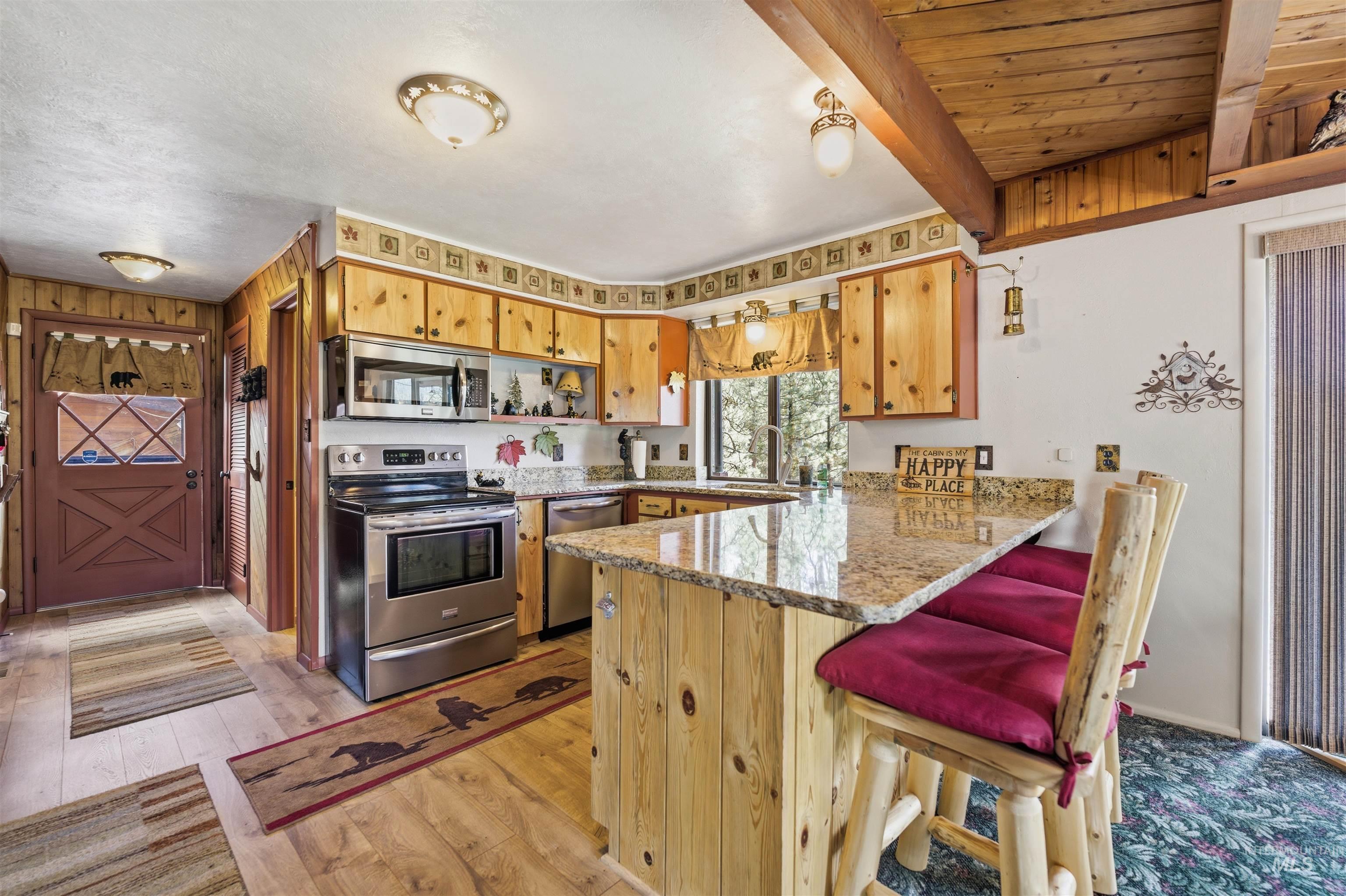 45 Rainbow Ridge Road Garden Valley, ID 83622 - Photo 17 of 41 Kitchen featuring stainless steel appliances, a peninsula, a breakfast bar, light wood finished floors, and light stone counters