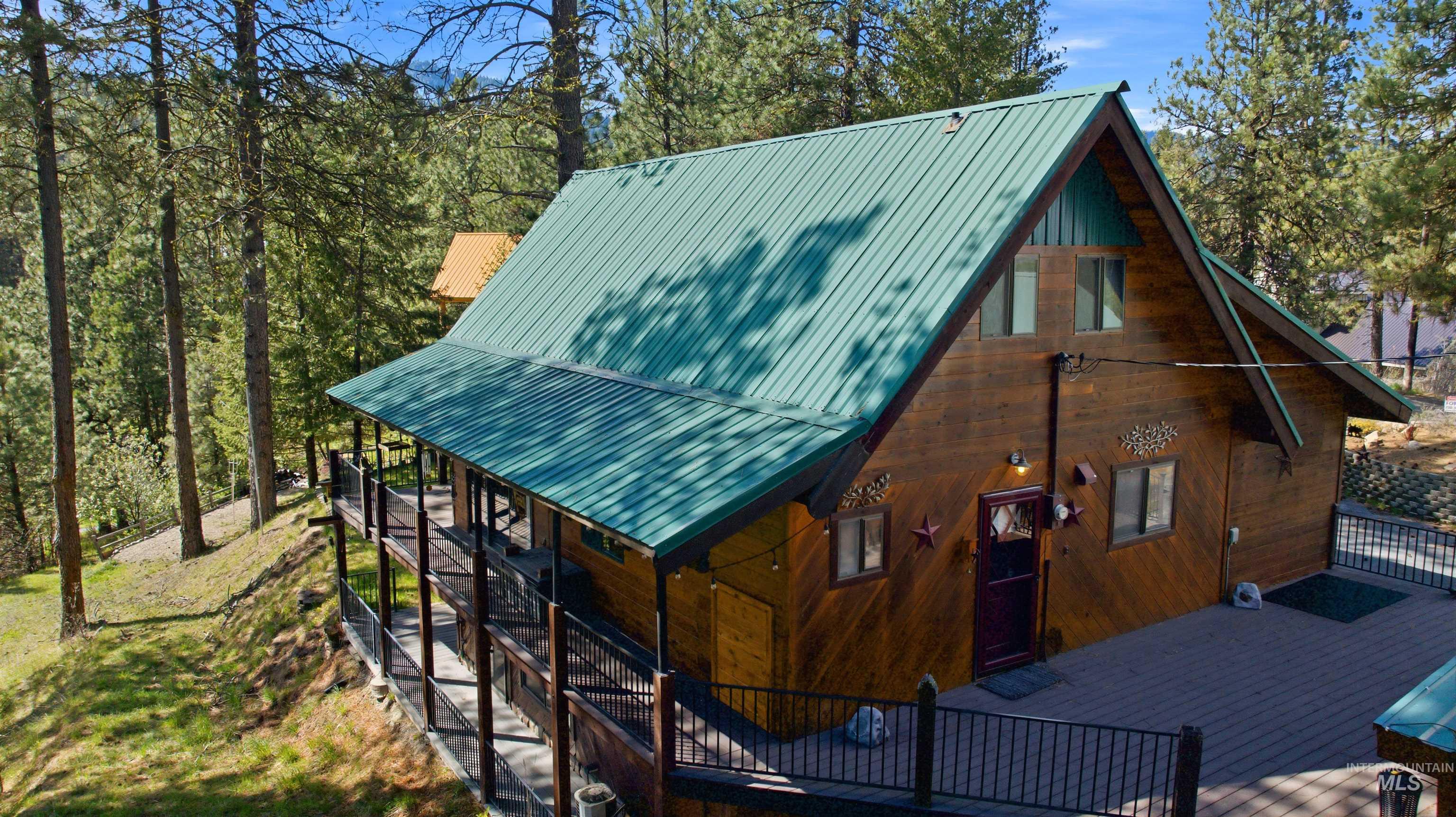 45 Rainbow Ridge Road Garden Valley, ID 83622 - Photo 3 of 41 View of home's exterior featuring a wooden deck and a metal roof