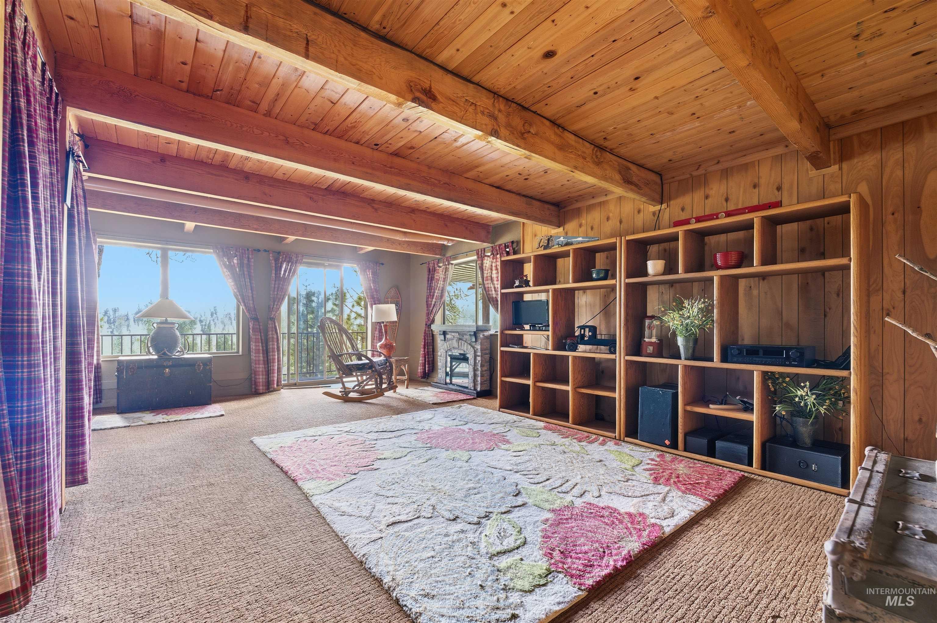 45 Rainbow Ridge Road Garden Valley, ID 83622 - Photo 36 of 41 Living area with a fireplace, carpet floors, and a wood ceiling with exposed beams