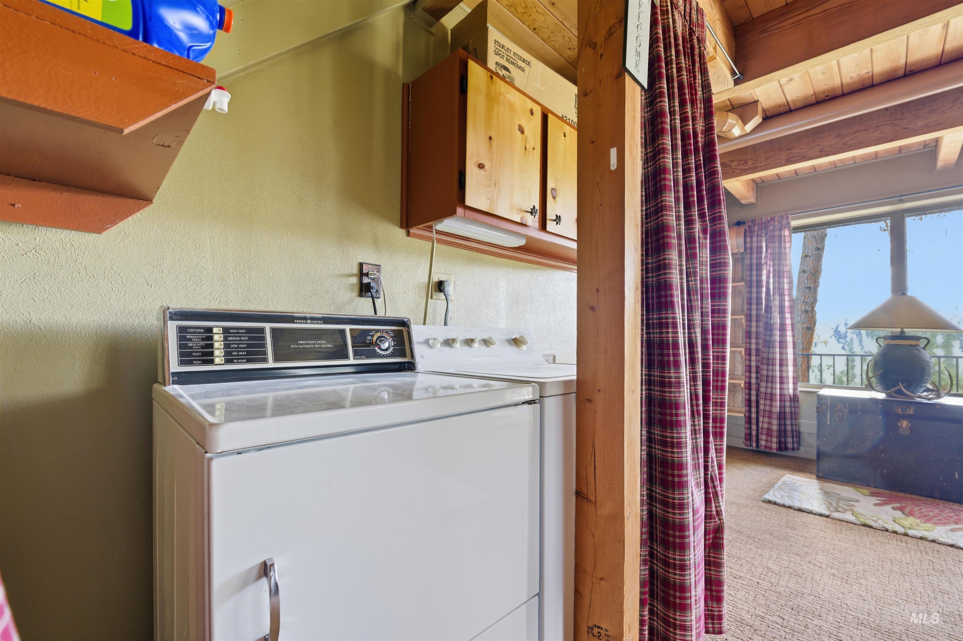 45 Rainbow Ridge Road Garden Valley, ID 83622 - Photo 37 of 41 Laundry room with washing machine and dryer, light carpet, beamed ceiling, and cabinet space