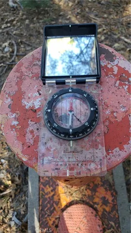 a view of a house with truck parked in a forest