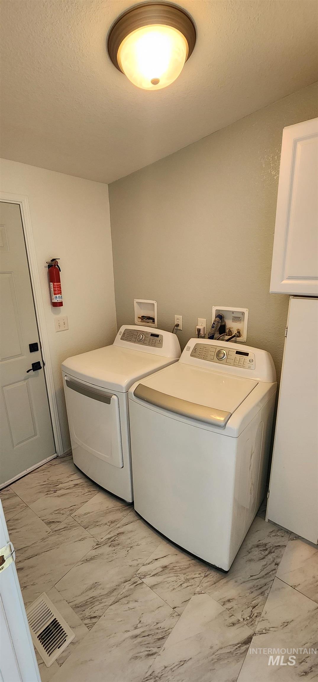 2115 6th Avenue, Unit 51 Clarkston, WA 99403 - Photo 11 of 45 Laundry room with washing machine and clothes dryer, light marble finish floors, and a textured ceiling