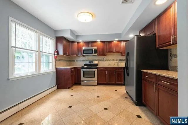 a kitchen with stainless steel appliances granite countertop a stove sink and a refrigerator