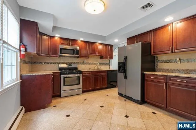 a kitchen with stainless steel appliances granite countertop a refrigerator stove top oven a sink and dishwasher