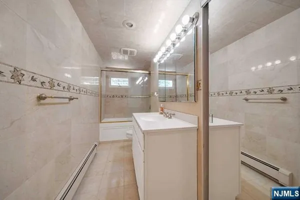 a bathroom with a shower a sink and a mirror