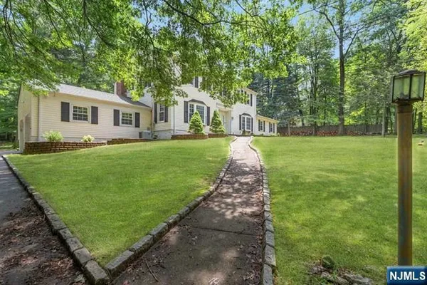 a front view of a house with a yard and trees
