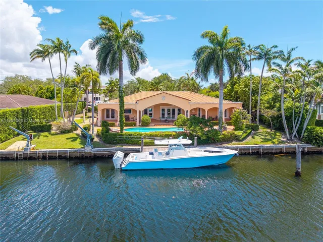 a view of an ocean with boats and palm trees