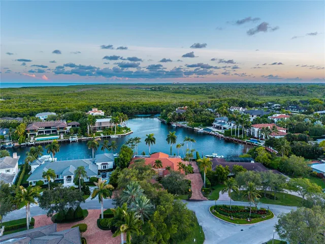 an aerial view of residential houses with outdoor space and lake view