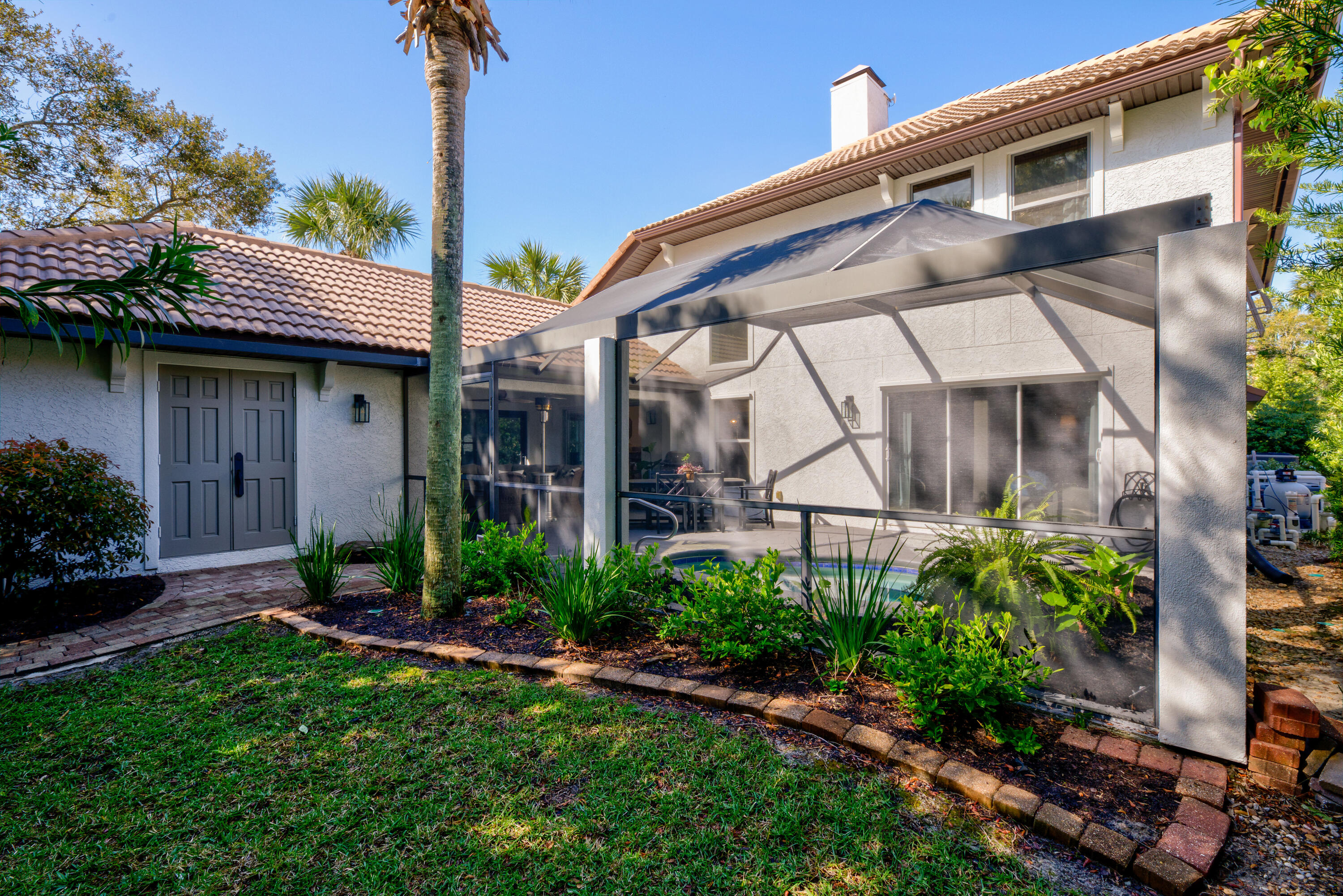 4639 Paradise Isle Destin, FL 32541 - Photo 10 of 67 a view of a house with brick walls and a yard with plants