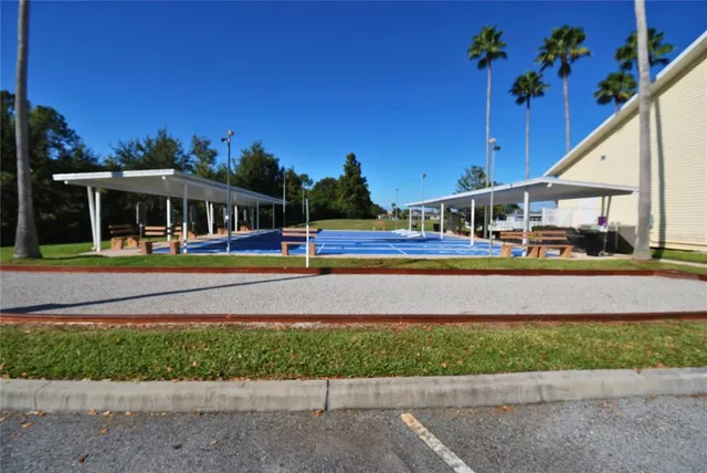 a view of swimming pool with outdoor seating and house in the background