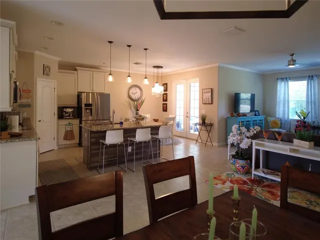 a living room with furniture kitchen view and a large window