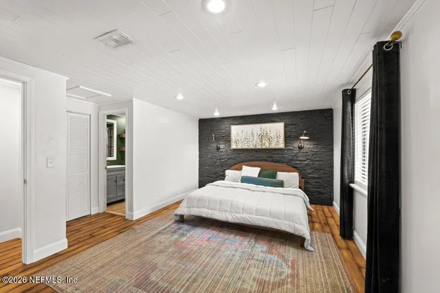 a bedroom with a bed and wooden floor