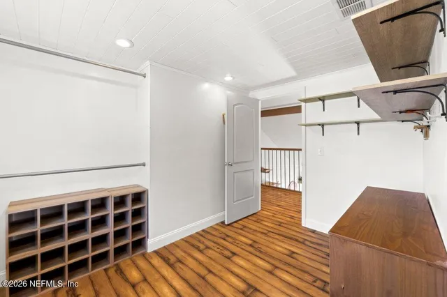 a view of empty room with wooden floor and cabinet