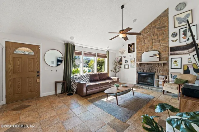 a living room with furniture a fireplace and a large mirror