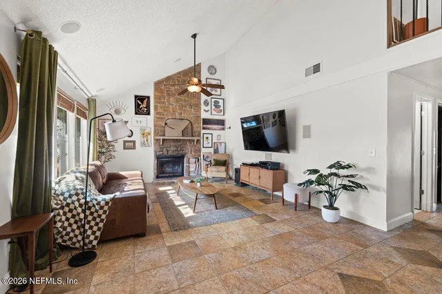 a living room with furniture a flat screen tv and a chandelier