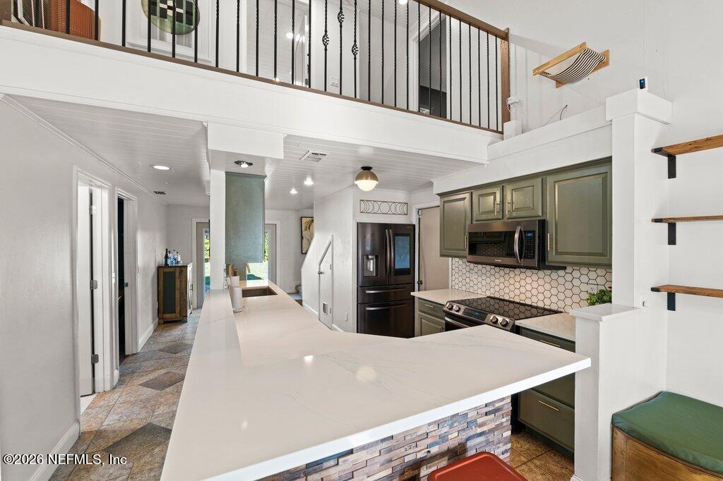 1810 Kings Way Neptune Beach, FL 32266 - Photo 9 of 40 a large kitchen with stainless steel appliances a large counter top a refrigerator and a sink