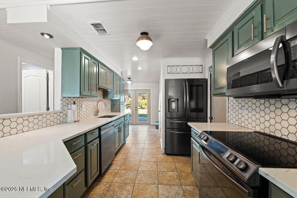 1810 Kings Way Neptune Beach, FL 32266 - Photo 10 of 40 a large kitchen with stainless steel appliances granite countertop a stove and a sink