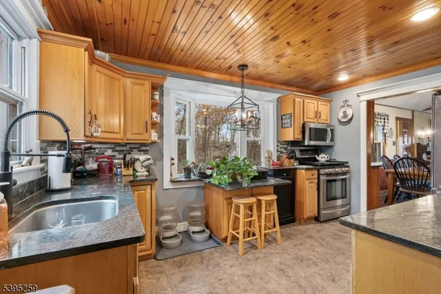 a kitchen with stainless steel appliances granite countertop sink stove top oven and cabinets