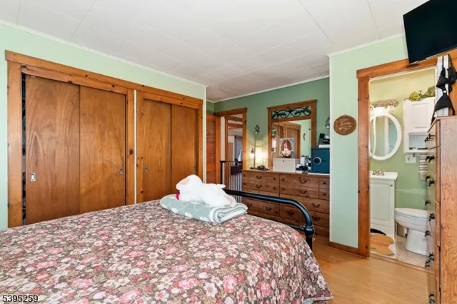 a bedroom with a bed and dresser with mirror