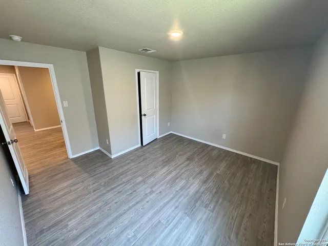 an empty room with wooden floor and sliding door