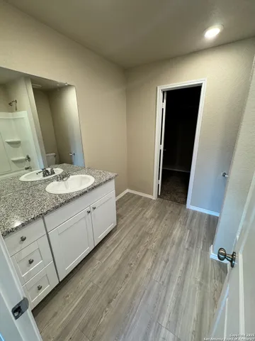 a spacious bathroom with a granite countertop sink and a mirror