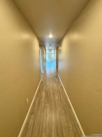 a view of a hallway with wooden floor