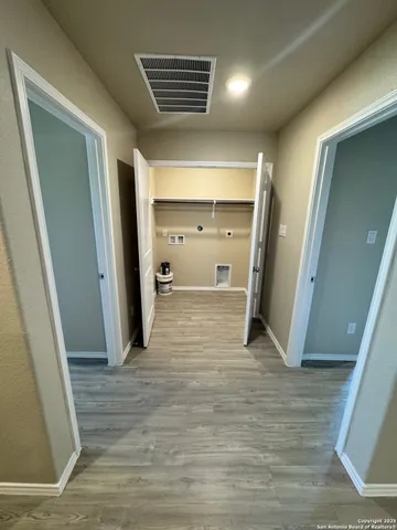 a view of a hallway with wooden cabinets