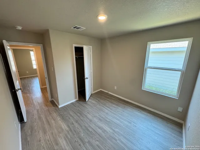 an empty room with wooden floor and a window