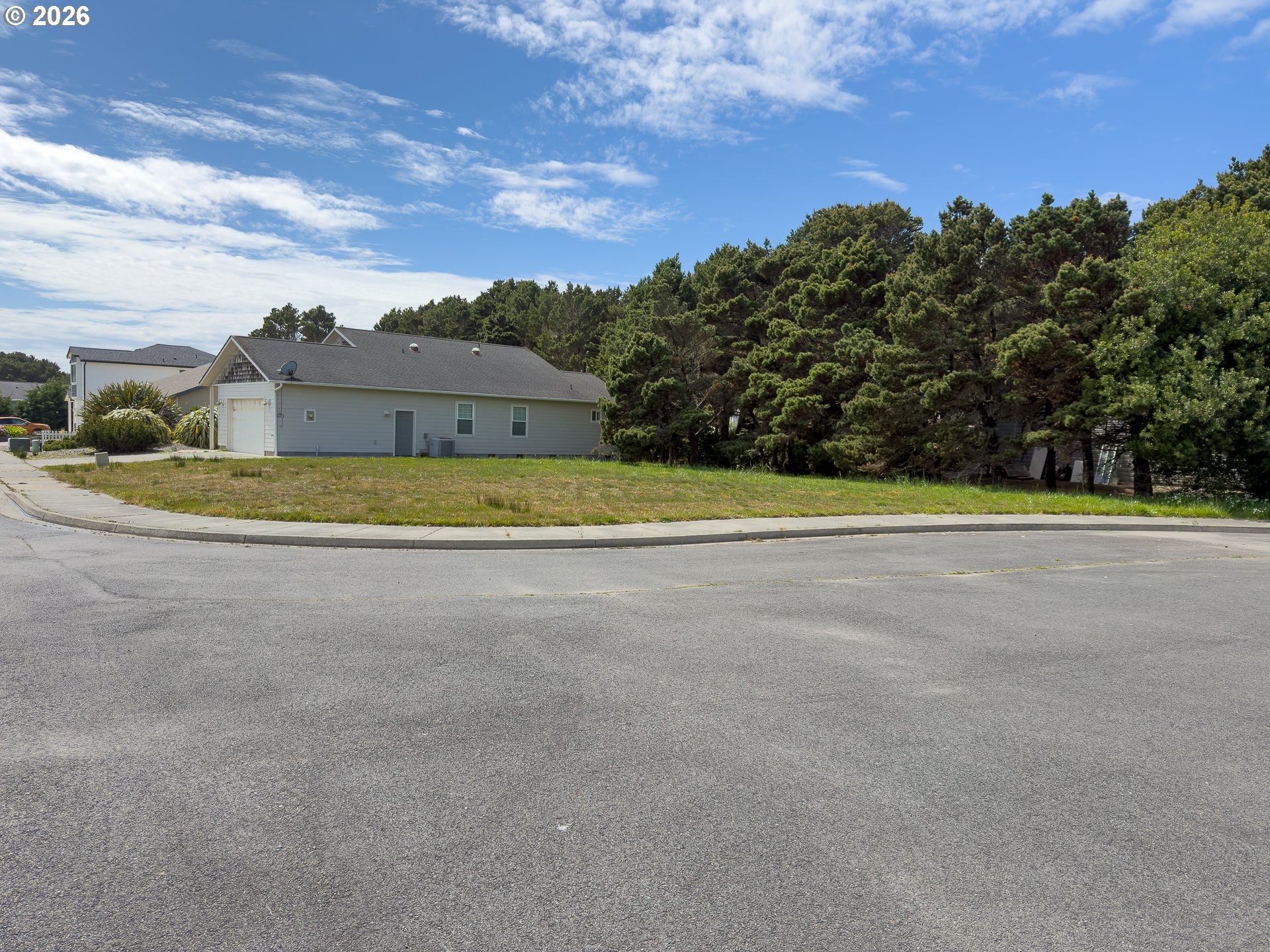 3122 Periwinkle Lane Southwest, Unit 5 Bandon, OR 97411 - Photo 7 of 13 a view of a big yard with a house in the background