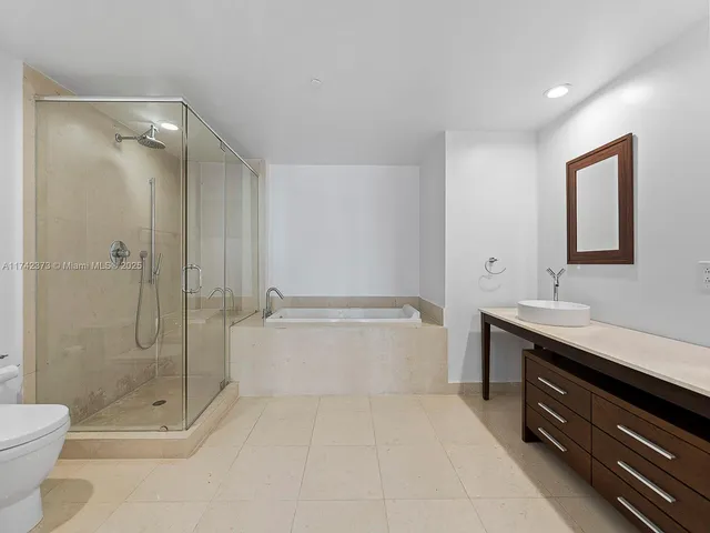 a spacious bathroom with a shower sink mirror and toilet