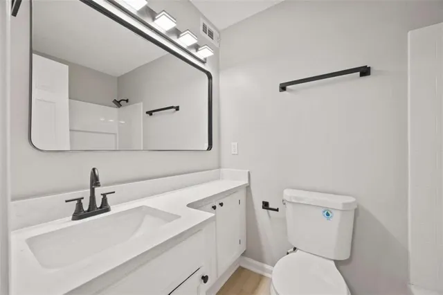 a bathroom with a sink a toilet and mirror