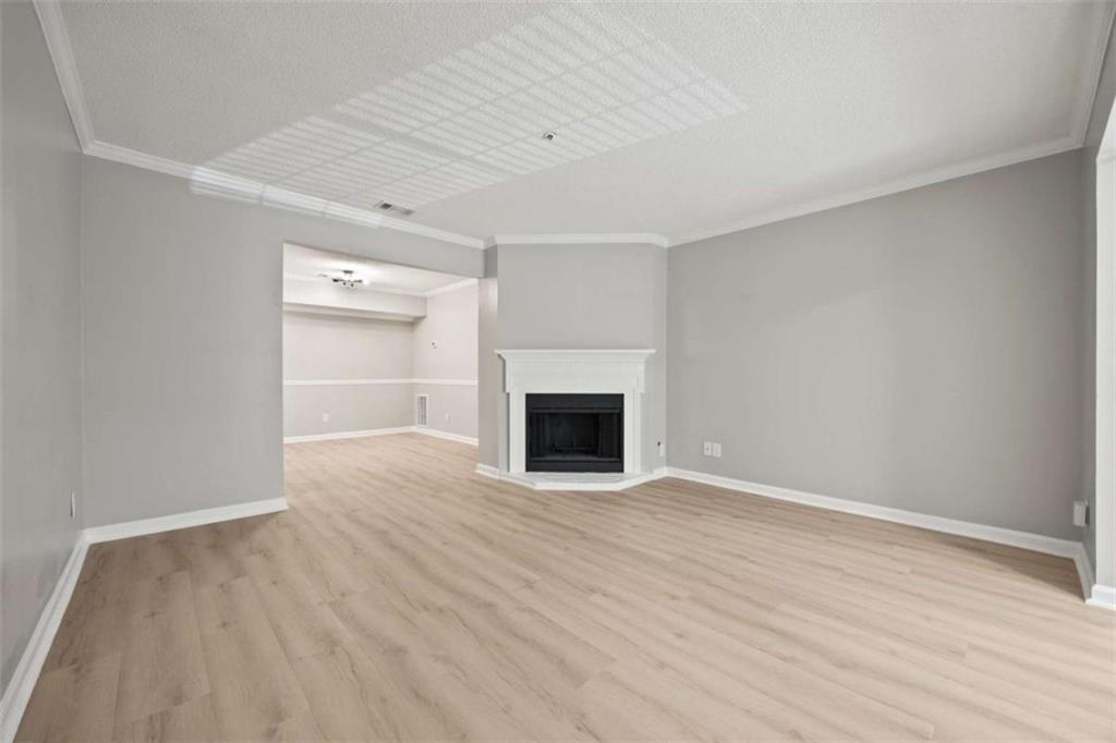 211 Cobblestone Trail Avondale Estates, GA 30002 - Photo 4 of 19 a view of an empty room with wooden floor fireplace and a window