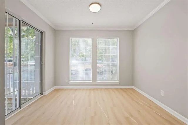 an empty room with wooden floor and windows