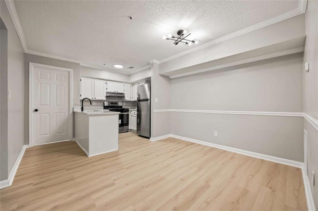 211 Cobblestone Trail Avondale Estates, GA 30002 - Photo 8 of 19 a view of an empty room with kitchen and wooden floor