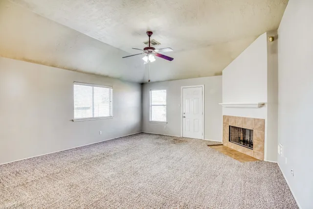 a view of empty room with fireplace and fan