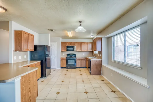 a large kitchen with cabinets and stainless steel appliances